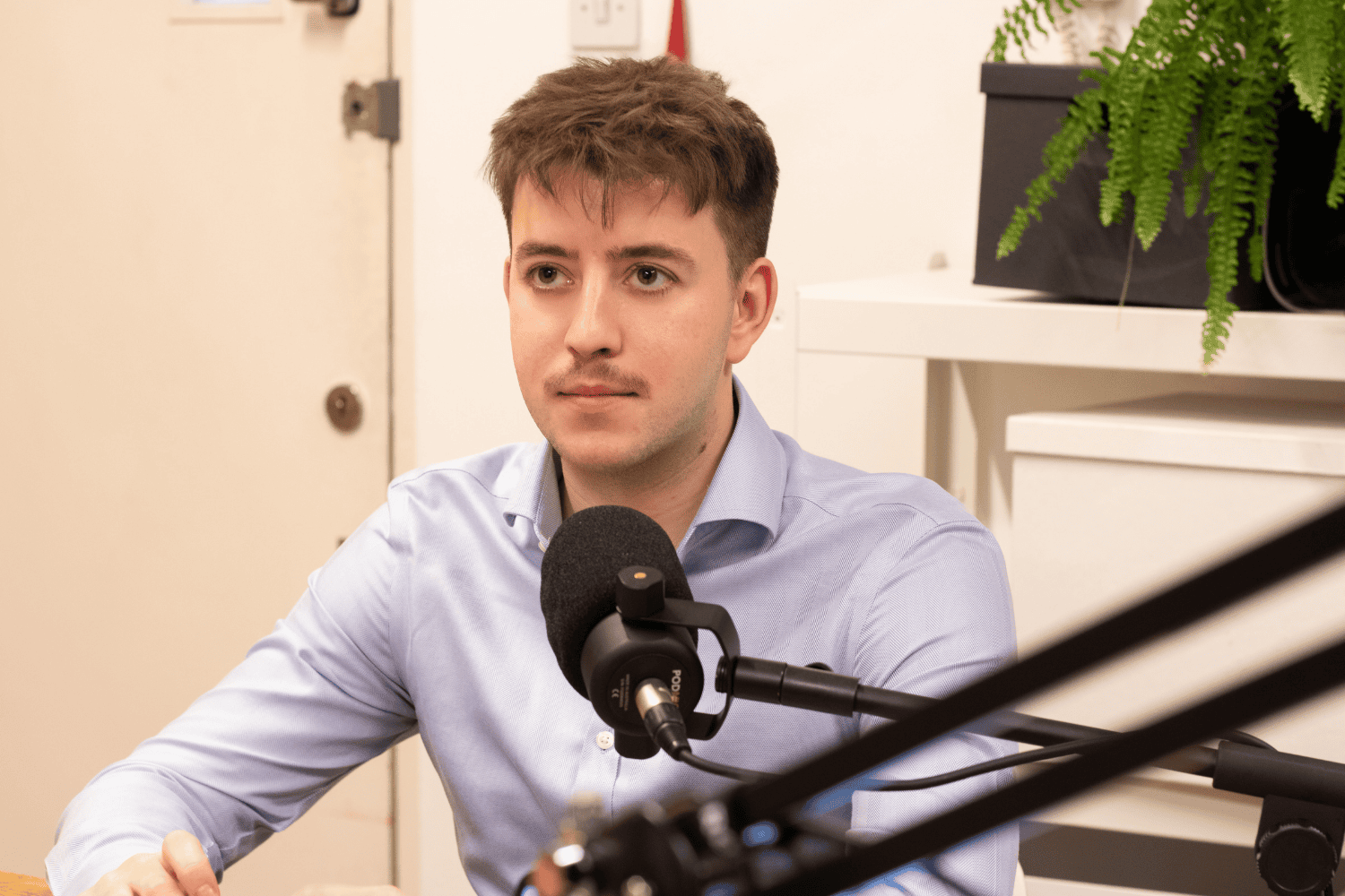 A podcast guest speaking into a microphone in the Profile recording studio.